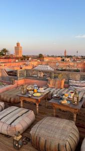 a patio with couches and tables on a roof at Riad Ksar Fawz & Spa in Marrakech