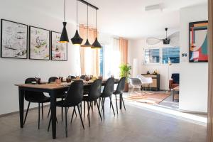 uma sala de jantar com uma mesa e cadeiras pretas em Villa Claber em Huningue