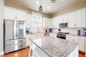 巴拿马城海滩Lagoon Luxury的厨房配有白色橱柜和花岗岩台面