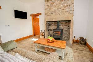 a living room with a table and a fireplace at Torties Cottage in Brampton