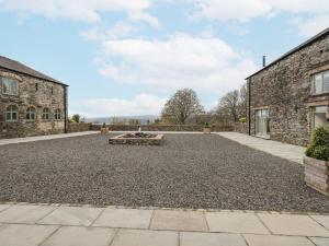 an empty courtyard in front of a stone building at Lime Cottage in Backbarrow