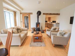 a living room with two couches and a fireplace at Lime Cottage in Backbarrow