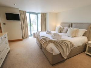 a bedroom with a large bed with towels on it at Lime Cottage in Backbarrow