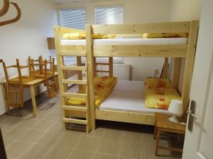 a room with two bunk beds and a table at Penzion U Lipna in Přední Výtoň