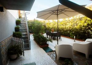 a patio with an umbrella and a table and chairs at Maria Home Reall's in Braga