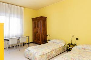 1 dormitorio con 2 camas y mesa con escritorio en [5 min Lake Orta] Free parking, en Gozzano