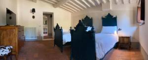 - une chambre dotée d'un grand lit avec des postes noirs dans l'établissement Borgo in Montalbano by Secret Hills, à Larciano