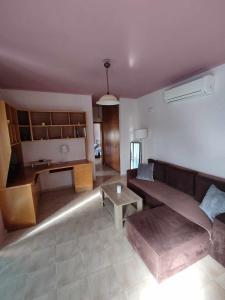 een woonkamer met een bank en een tafel bij Dinos Pool Apartment in Kardamaina