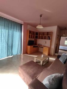 een woonkamer met een bank en een tafel bij Dinos Pool Apartment in Kardamaina