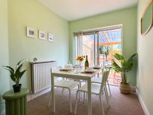 a dining room with a white table and chairs at Luxury 2-bedroom Townhouse in Central Canterbury with Hot Tub, Garden & Private Parking! in Canterbury