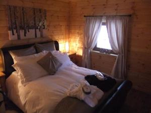 a bedroom with a white bed with a window at Deerdale Lodge in Bilsthorpe