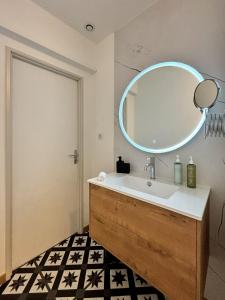 bagno con lavandino e specchio a parete di Le Oliva chez les M by Primo Conciergerie a Nevers