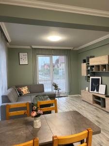 una sala de estar con un sofá y una mesa en Becca Apartment 2, en Sînmartin