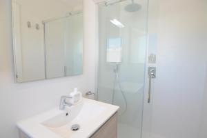 a bathroom with a sink and a shower with a mirror at Apartamentos Casa Franziska in Talamanca