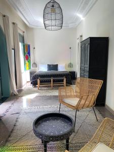 a bedroom with a bed and a chair and a table at Riad Ksar Fawz & Spa in Marrakech
