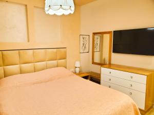 a bedroom with a bed and a flat screen tv at Central Luxe Apartment in Tirana