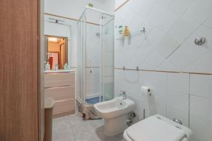 a white bathroom with a toilet and a sink at Cozy Nest for Families in Rome
