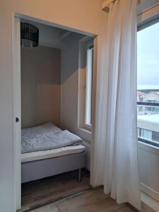 Habitación pequeña con cama y ventana en Top Floor City Apartment, en Rovaniemi