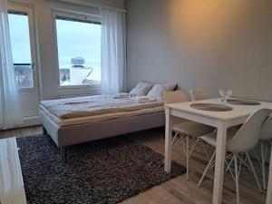 1 dormitorio con cama, mesa y ventana en Top Floor City Apartment, en Rovaniemi