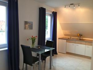 a dining room with a table and chairs and a kitchen at Ferienwohnung in Patzig auf Rügen in Patzig