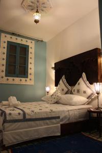 a bedroom with a large bed with white pillows at Ryad Meknassia in Meknès