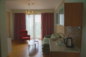 a living room with a green couch and a red chair at Omr park Suites in Istanbul