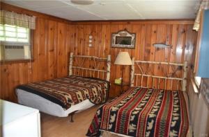 2 Betten in einem Zimmer mit Holzwänden in der Unterkunft The Lakeside Lodge 