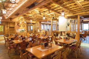a restaurant with wooden tables and chairs and windows at Wellness-Hotel ADLER in Bad Wörishofen