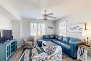 a living room with a blue couch and a tv at Whale & Whelk in Buxton