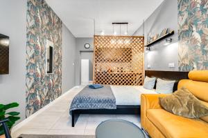 ein Schlafzimmer mit einem Bett und einem Sofa in der Unterkunft PAPUGA Apartment ~ 700m Main Square ~ Self check-in 24h in Breslau