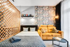 ein Schlafzimmer mit einem Bett und einem Sofa in der Unterkunft PAPUGA Apartment ~ 700m Main Square ~ Self check-in 24h in Breslau
