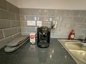 a coffee maker sitting on a counter next to a sink at Luxury Boutique Apartments Block Free Street Parking in Hounslow