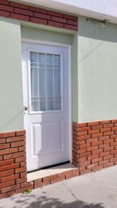 una puerta blanca en un edificio de ladrillo con una ventana en Soñar en la Patagonia en Trelew