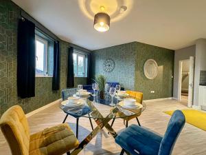 a dining room with a glass table and chairs at Luxury Boutique Apartments Block Free Street Parking in Hounslow