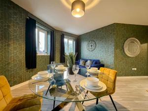 a dining room with a glass table and yellow chairs at Luxury Boutique Apartments Block Free Street Parking in Hounslow