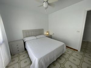 een slaapkamer met een wit bed en een plafondventilator bij Calabardina Playa 2 con Wifi in Calabardina