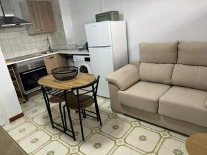 a living room with a couch and a table and a kitchen at Calabardina Playa 2 con Wifi y aire acondicionado in Calabardina