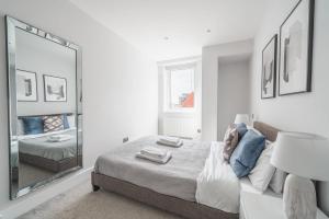 1 dormitorio con cama y espejo grande en Lovely 1 Bedroom Apartment in Eastleigh Town Centre en Eastleigh