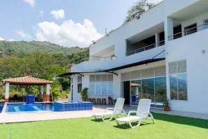 a villa with a swimming pool and lawn at Finca Rosa Linda Stunning Views Jacuzzi Pool in Sopetrán