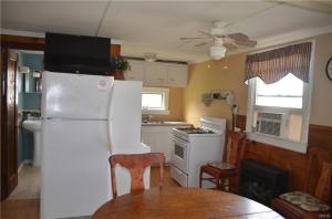 eine Küche mit einem weißen Kühlschrank und einem Tisch in der Unterkunft The Lakeside Lodge 