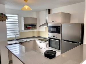 una cucina con frigorifero in acciaio inox e lavello di Ilet Madras - Trois-Ilets a Les Trois-Îlets