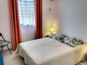 una camera da letto con un letto con due cuscini e una finestra di Ilet Madras - Trois-Ilets a Les Trois-Îlets