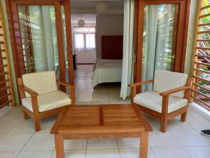 um quarto com duas cadeiras, uma mesa e uma cama em Bungalows & Suites Punta Camarón em Zorritos