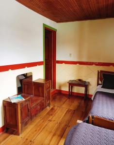 een slaapkamer met een bed, een dressoir en een tafel bij Hostal Restaurante La Gata Carola in Salento