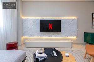 a living room with a tv and a white couch at Prime Residence Point 90 in Cairo