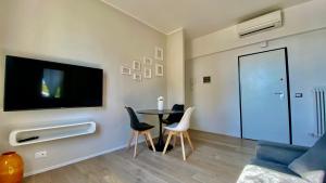 sala de estar con mesa, sillas y TV en Suite649 Nuova 5 en Modena