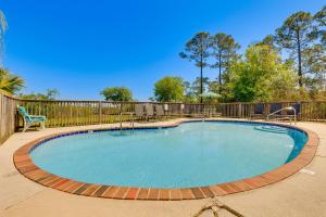 a swimming pool in a yard with a fence at Water View Dauphin Island Condo with Boat Slips in Dauphin Island