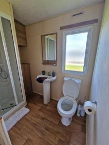 uma pequena casa de banho com WC e lavatório em B17 Sunnymede Caravan Park, Fantasy Island, Ingoldmells em Ingoldmells