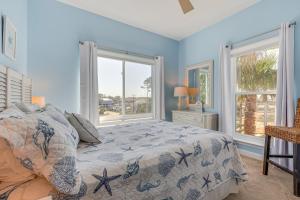 a bedroom with a bed and two windows at Water View Dauphin Island Condo with Boat Slips in Dauphin Island +29 photos