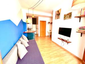 Catedral Apartments في فالنسيا: غرفة معيشة مع أريكة وتلفزيون بشاشة مسطحة